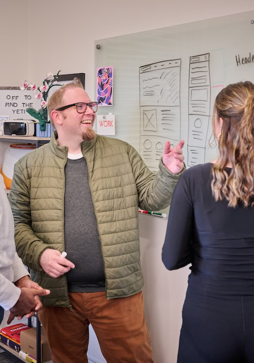 MESH employees brainstorming at a whiteboard