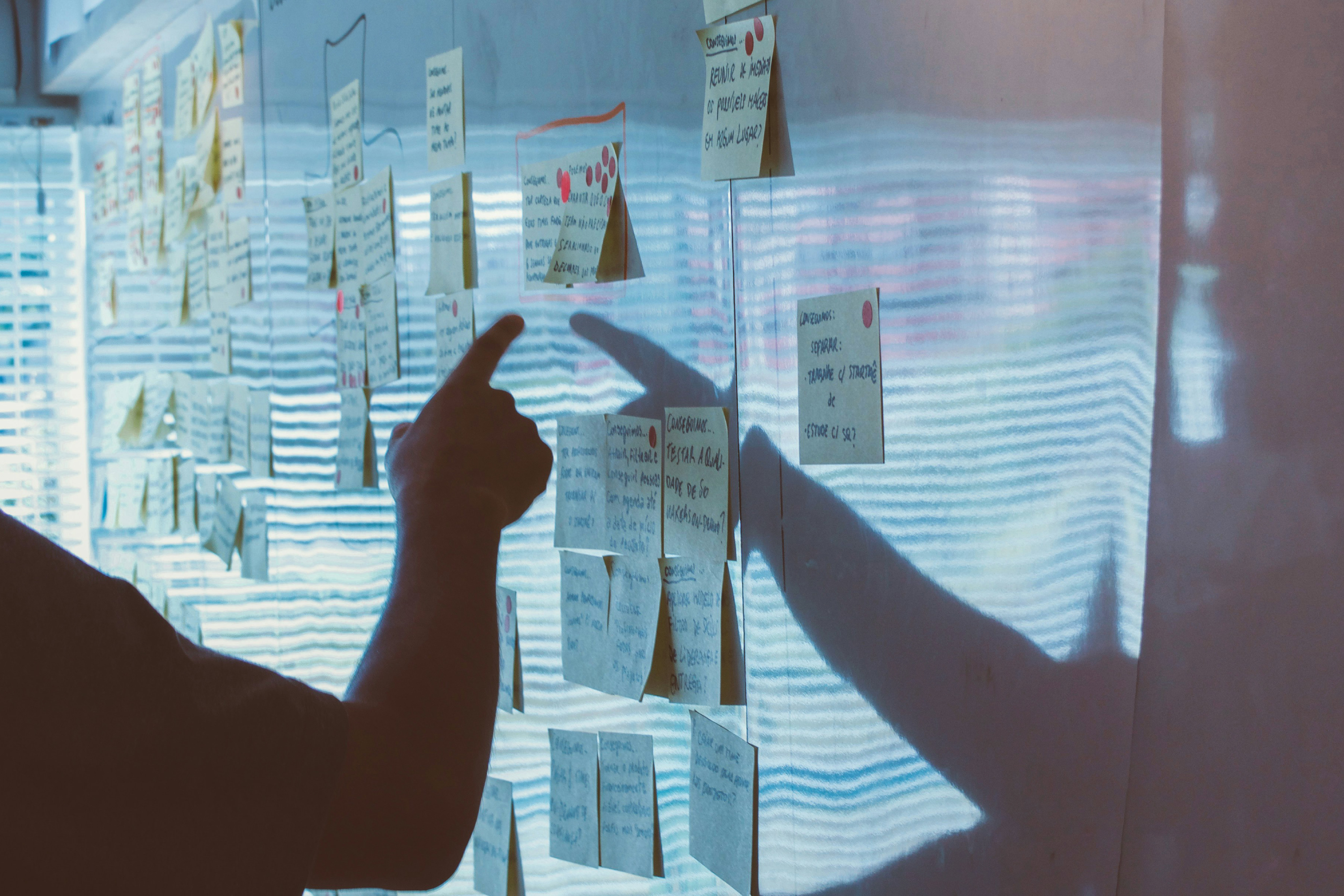person pointing to notes on a whiteboard