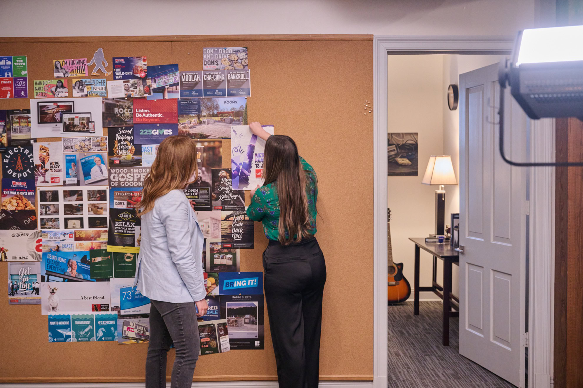 woman displaying creative on cork board