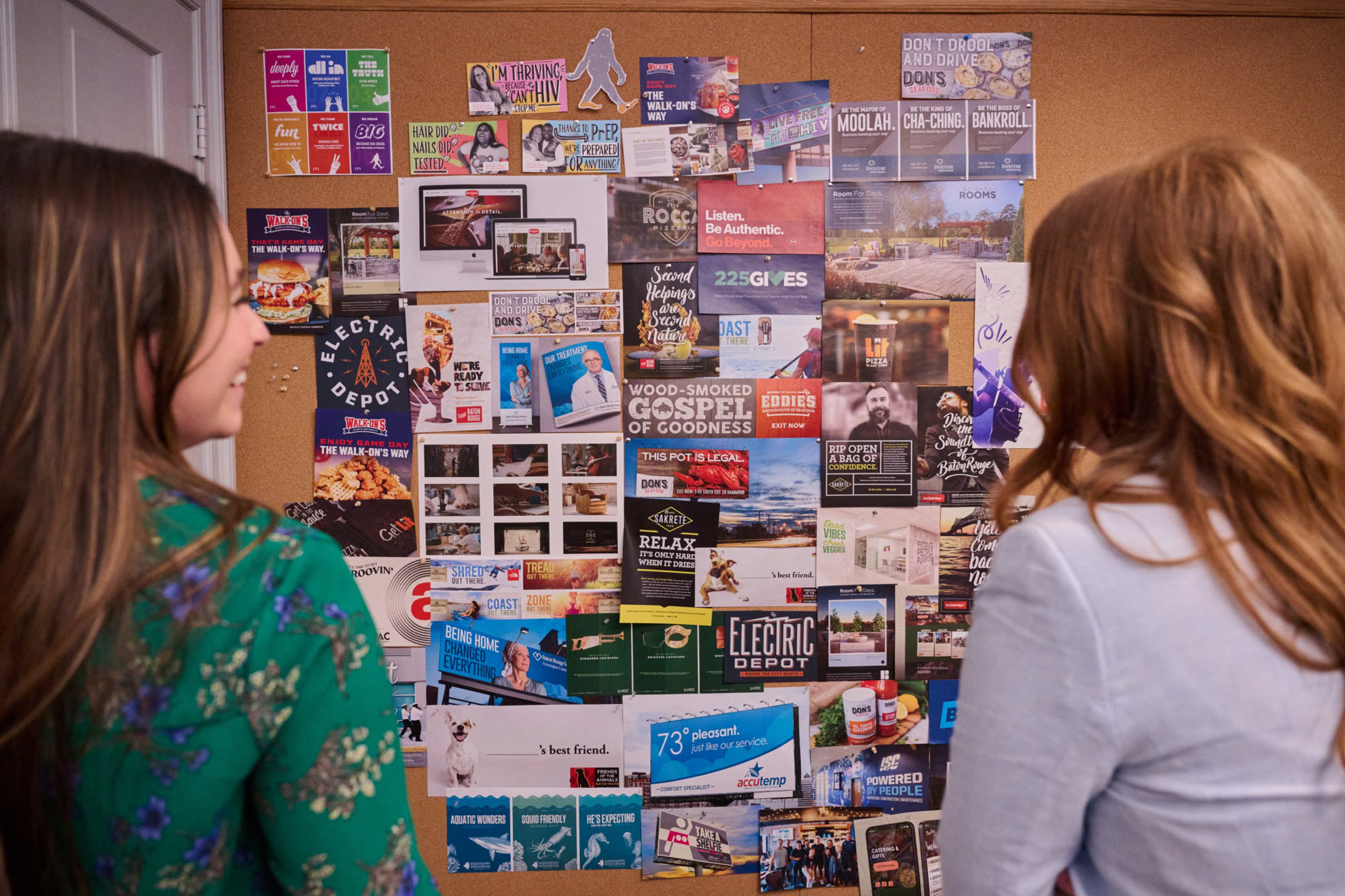 Two mesh coworkers standing side by side and looking at creative work by MESH