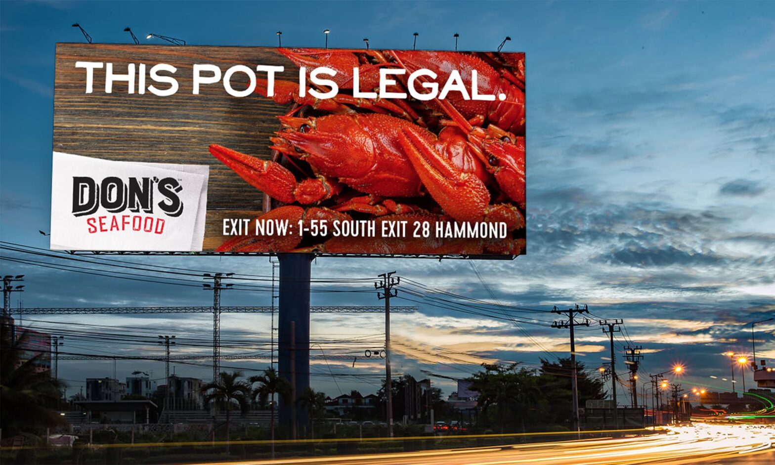 Billboard showing crawfish, captioned "This pot is legal." with directions to a Don's Seafood location