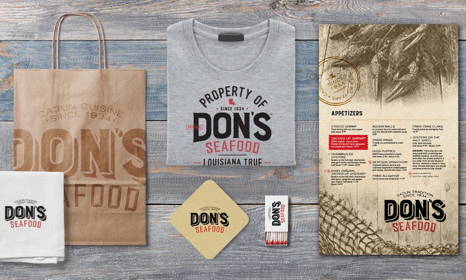 Array of Don's Seafood branded to-go bag, napkin, t-shirt, menu, coaster and matchbox.